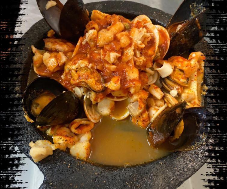 Molcajete Marino · Tilapia, shrimp, calamari, scallops, squid, clams, and mussels. Served with rice, beans, crema salad, and tortillas. 