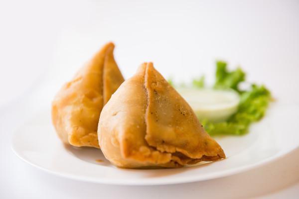 Samosas  · Homemade potato and green peas filling in a flaky turnover flavored with ajwain (carom seeds). Served with Mint chutney and tamarind sauce. vegan 