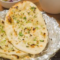 Garlic Naan · Round shaped flat bread baked in tandoor with a touch on minced garlic & butter.