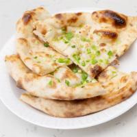 Bullet Naan · Round shaped flat bread baked in tandoor with a touch on jalapenos, cilantro & butter.