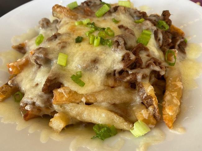 Brisket Poutine · Crispy hand cut fries topped with our Guinness braised brisket, melted white cheddar, brown gravy and green onions
