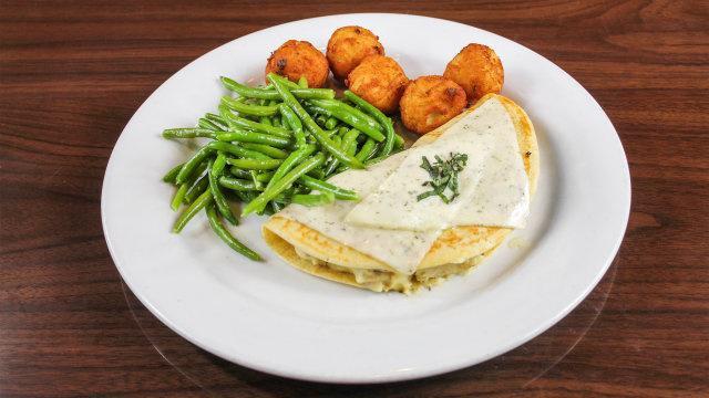 The Killarney · A traditional Irish potato pancake with marinated chicken in a béchamel sauce, finished with creamy havarti cheese & fresh basil.  Served with potato croquettes & haircots vert.