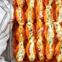 Stuffed Shells · Large shells of pasta filled with spinach and ricotta, on a bed of our signature marinara sa...