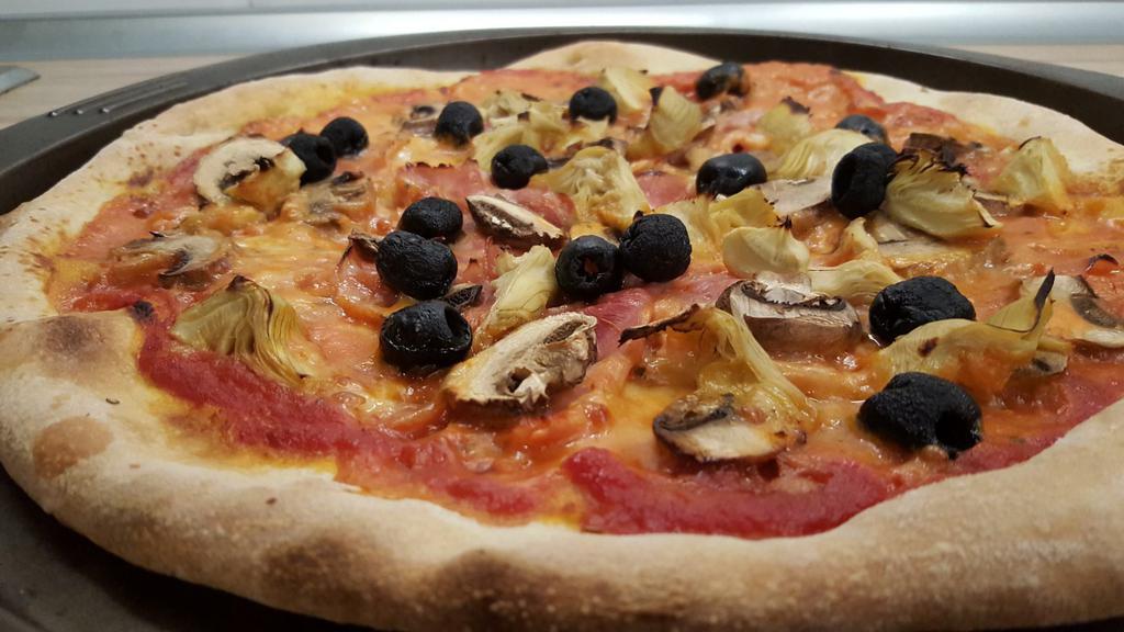 Capricciosa Pizza · Tomato sauce, fresh grated mozzarella, portabello and porcini mushrooms, prosciutto, artichokes drizzled with a truffle oil.