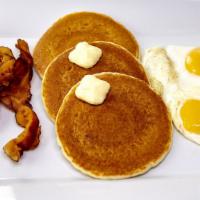 12. Huevos con Tocino y Pancakes · Eggs w/ bacon & Pancakes. Served with fries and coffee with milk and bread with butter.