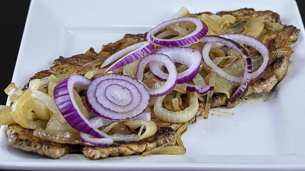 Bistec de Cerdo a la Plancha · Grilled pork steak.