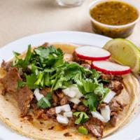 Steak Taco · Topped with onions and cilantro, lime wedge, radish. Choice of sauce.