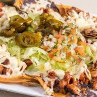 Al Pastor Nachos · Refried beans, melted cheese, lettuce, jalapenos and pico de gallo.