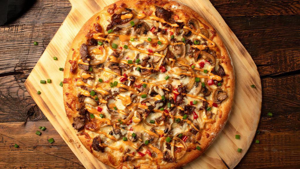 Philly Cheesesteak Pizza · Grilled sirloin and onions, Voodoo Ranger Queso, mozzarella cheese, red pepper and chipotle aioli 