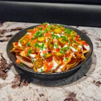 Primo Nachos · Oven baked with chicken, beef or pork, bacon, and cheddar. Topped with tomatoes, jalapenos, ...