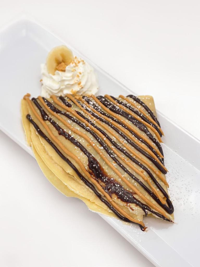 Chunky Monkey Crêpe · Peanut butter + Chocolate + Sliced bananas. Served with a sprinkle of powdered sugar and whipped cream.