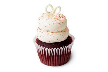 Scarlett's Red Velvet Cupcake · Red velvet cake filled with vanilla pudding, topped with our famous cream cheese frosting, sprinkled with red sanding sugar and topped with a white chocolate heart.