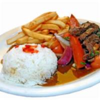Lomo Saltado · Strips of beef sautéed with onions, tomatoes, soy sauce served over French fries and white r...