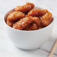 Sesame Chicken · Crispy, tempura chicken tossed in a sweet and tangy sauce, garnished with sesame seeds.