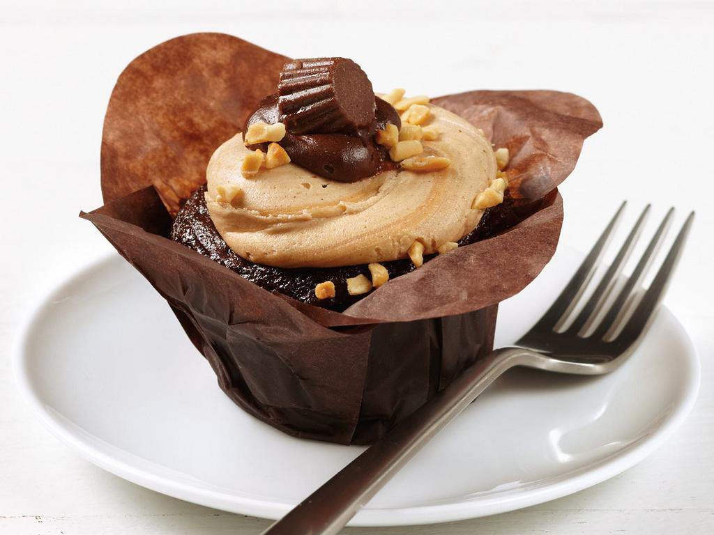 Peanut Butter Cup Cupcake · Rich, decadent, milk chocolate cake topped with creamy peanut butter icing. Garnished with a peanut butter cup.