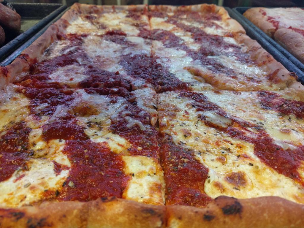 Grandma Pizza · Mozzarella and Parmesan with marinara sauce and basil on top.