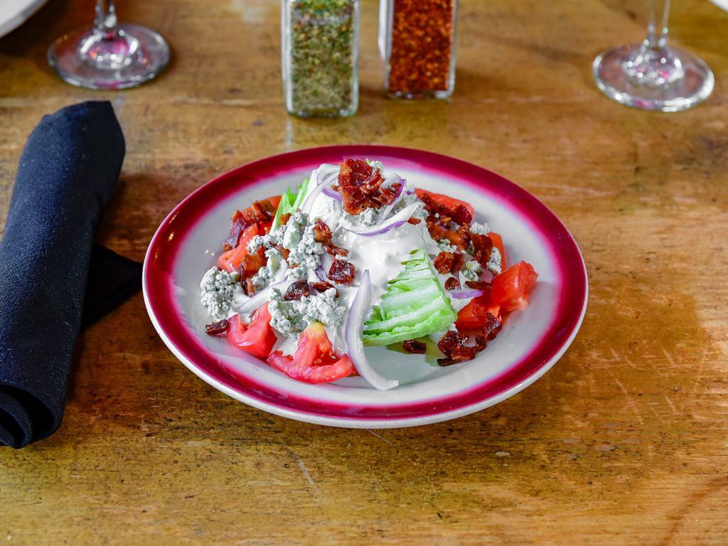 Wedge Salad · Crisp iceberg lettuce. Served with tomatoes, bacon, red onion, homemade creamy blue cheese and crumbled Gorgonzola.