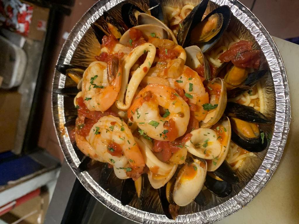 Seafood Combination · Shrimp, mussels, calamari and clams over pasta.