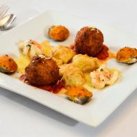 Arancini · Deep-fried breaded rice stuffed with peas and cheese and served with marinara sauce.