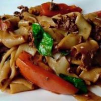 Pad Kee-Mao · Thai drunken noodle. Large wide noodles stir-fry with garlic, basil and tomato.