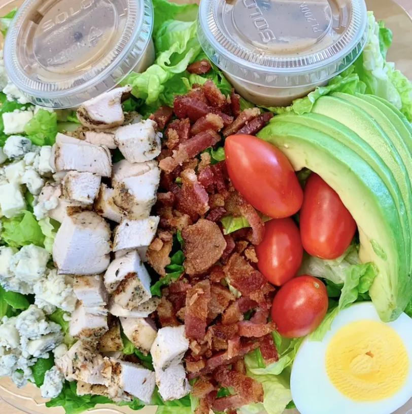 Cobb Salad · Romaine hearts, hard-boiled egg, blue cheese, free-range grilled chicken, bacon, avocado, and grape tomatoes.