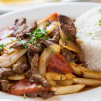 Lomo Saltado · Sliced beef chunks sauteed with red onions and tomatoes, served over french fries.