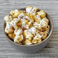 Birthday Cake Popcorn · Caramel popcorn drizzled with vanilla infused white chocolate and topped colorful sprinkles.

