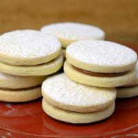 Alfajor · Soft delicate cookie from South America. Filled with dulce de leche and rolled in coconut fl...