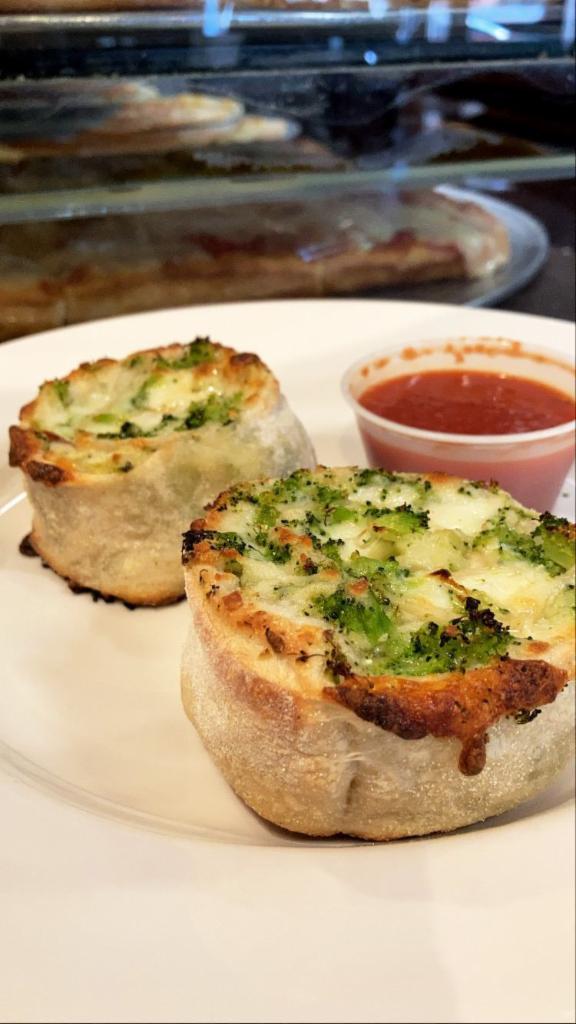 Broccoli Pinwheel · Homemade pizza dough and broccoli rolled up then sliced into thick pieces. Baked golden brown.