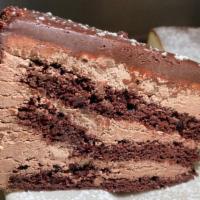 Chocolate Cake · Dark chocolate cake with dark chocolate icing and semi-sweet chocolate pieces. Dusted with D...