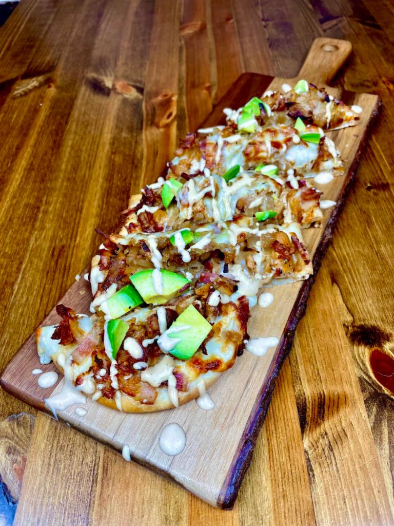 California Chicken Flatbread · Grilled chicken, bacon bits, caramelized onions, pepper jack cheese, avocado, topped with chipotle ranch.