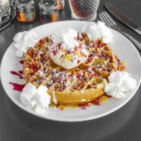 Fruity Pebbles Waffle · Baked with fruity pebbles cereal, topped with vanilla ice cream, vanilla sauce, and raspberr...