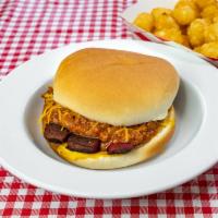 Texas Link with Chili and Grated Cheese Sandwich · A sliced hot link on a hamburger bun with mustard, chili, and cheese.