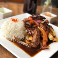 Lomo Saltado · Traditional Peruvian style stir fry beef tenderloin and sauteed with onions. Tomatoes, cilan...