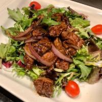 32. Beef Luc Lac  · Cubed beef tenderloin marinated in rice wine, tossed in butter and yellow onions with mixed ...