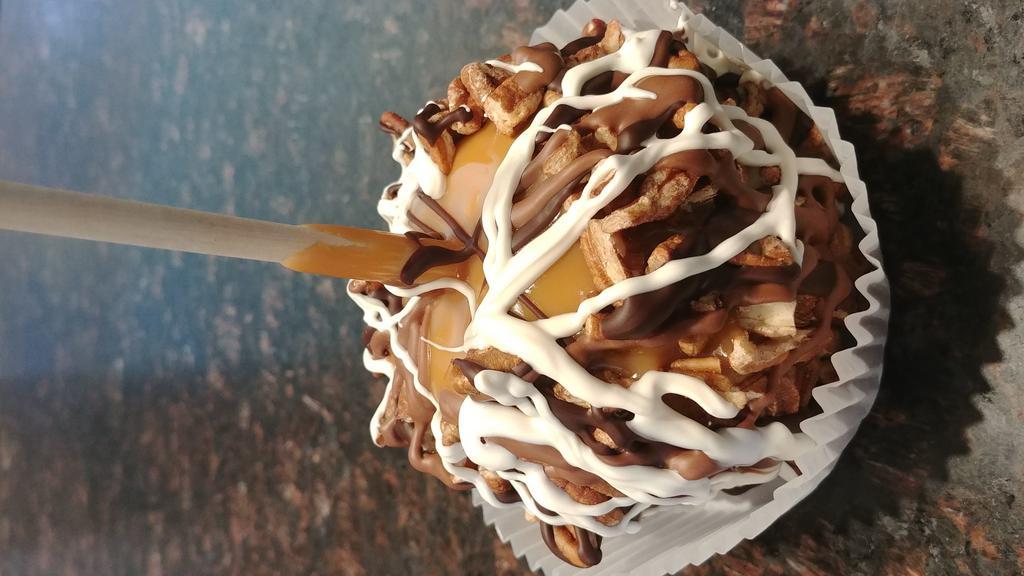Pecan Turtle Caramel Apple · Granny Smith Apple, Handmade Caramel, rolled in pecans, then drizzled in milk chocolate and white.