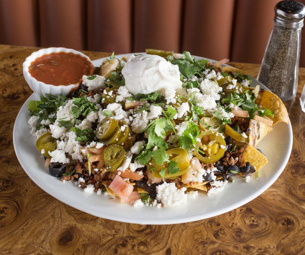 Nacho Platter · Loaded with taco seasoned beef, refried beans, cheese, jalapenos, tomatoes, olives, sour cream and salsa.