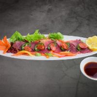 Tuna Tataki · Seared tuna with black pepper topped with marinated onions, scallions with ponzu vinaigrette