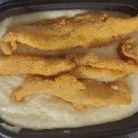Catfish and Grits  · Golden Crispy fillets fried to perfection, served over some Southern style harmony grits wit...