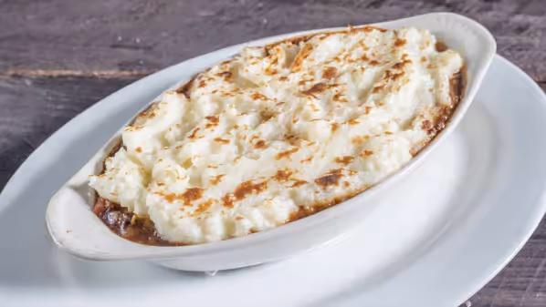 Shepherd's Pie · Grass-fed ground beef, slow braised with root vegetables in Guinness beer and house beef au jus, topped with whipped mashed potatoes and gently browned.