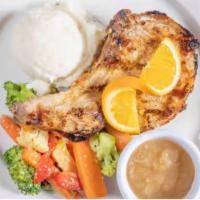 Grilled Marinated Double-Cut Pork Chop · Served with mashed potatoes and house vegetables.