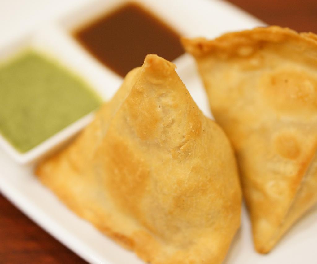 Vegetable Samosa (2 pieces) · A turnover filled with seasoned vegetables served with mint and tamarind chutney. 