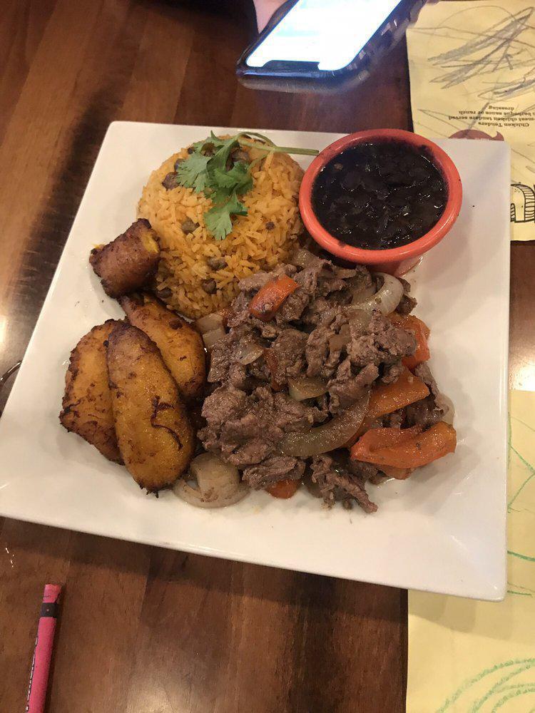 Pepper Steak Dinner Plate · Sauteed thinly sliced top sirloin steak with peppers and onions, and served with either arroz con gandules (yellow rice and pigeon peas) or white rice with red or black beans and maduros (sweet plantains) OR tostones (fried crispy green plantains) 