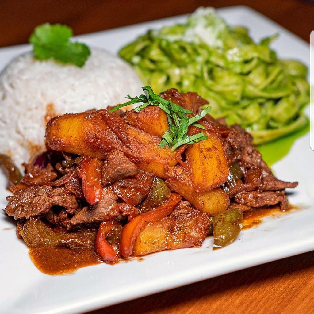 Lomo Saltado · A traditional Peruvian dish, a stir fry that combines marinated strips of sirloin with red onions, tomatoes, potatoes, and is served with white rice and a side of sweet plantains (maduros)