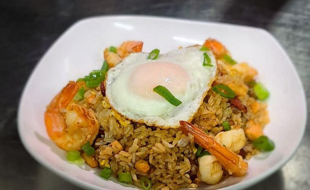 Bodega Fried Rice (Chaulafan) · Fried rice made with chicken, pork belly, shrimp, onions, scallions, garlic, peppers, pigeon peas, carrots, eggs, spices, and topped with a fried egg