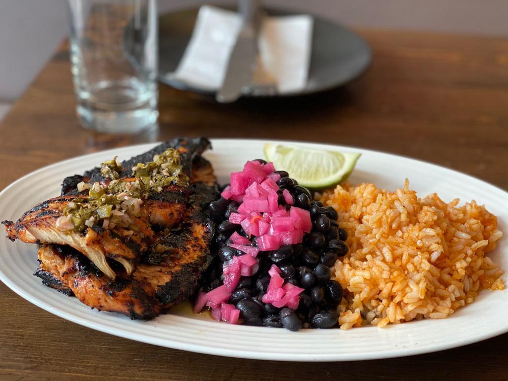 Chicken al Carbon · Chicken breast marinated with guajillo, honey, and lime and grilled. Served with rice and black beans and our homemade chimichurri.