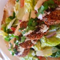 Falafel Wrap · Vegan. 4 crispy chickpea croquettes, lettuce, red onions, and tomatoes, wrapped on Naan brea...