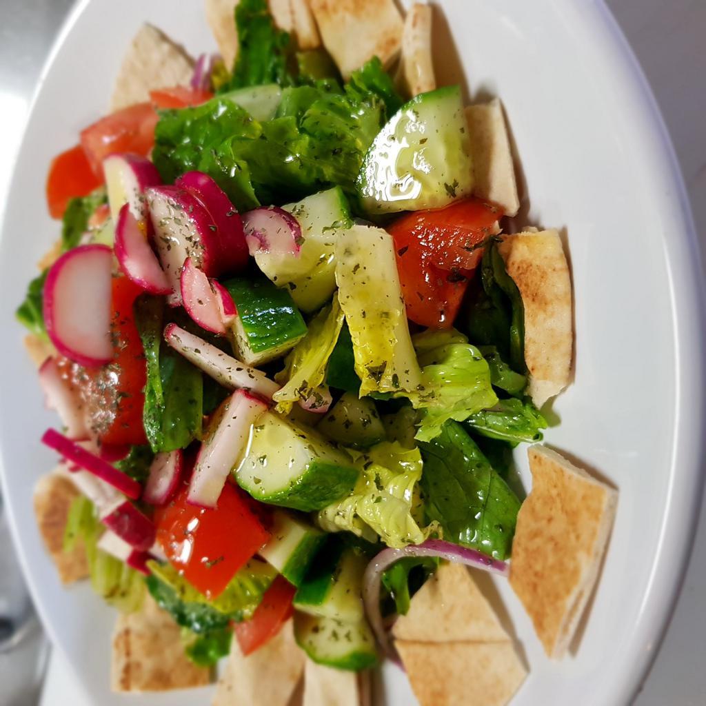 Fattoush Salad · Baby lettuce, romaine lettuce, red onions, radishes, tomatoes, mint, garlic olive oil dressing and toasted Lebanese bread. Vegan.