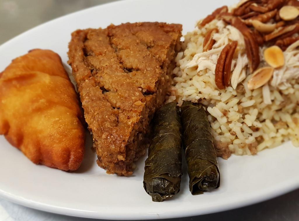 Lebanese Sampler · 1 baked kibbeh, 2 grape leaves, 1 empanada, 1 kousa mahshi, layali rice and a side of tabbouleh of hummus. Contains pecan, almonds and pine nuts.