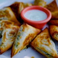 Baked Feta Cheese and Spinach Bites · Filo dough triangles stuffed with sauteed spinach, and feta baked to a golden crisp. Served ...